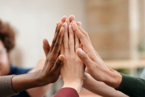 Decorative image to represent a four way partnership of four people 'high fiving'.