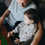 Father Holding A Book Beside His Child