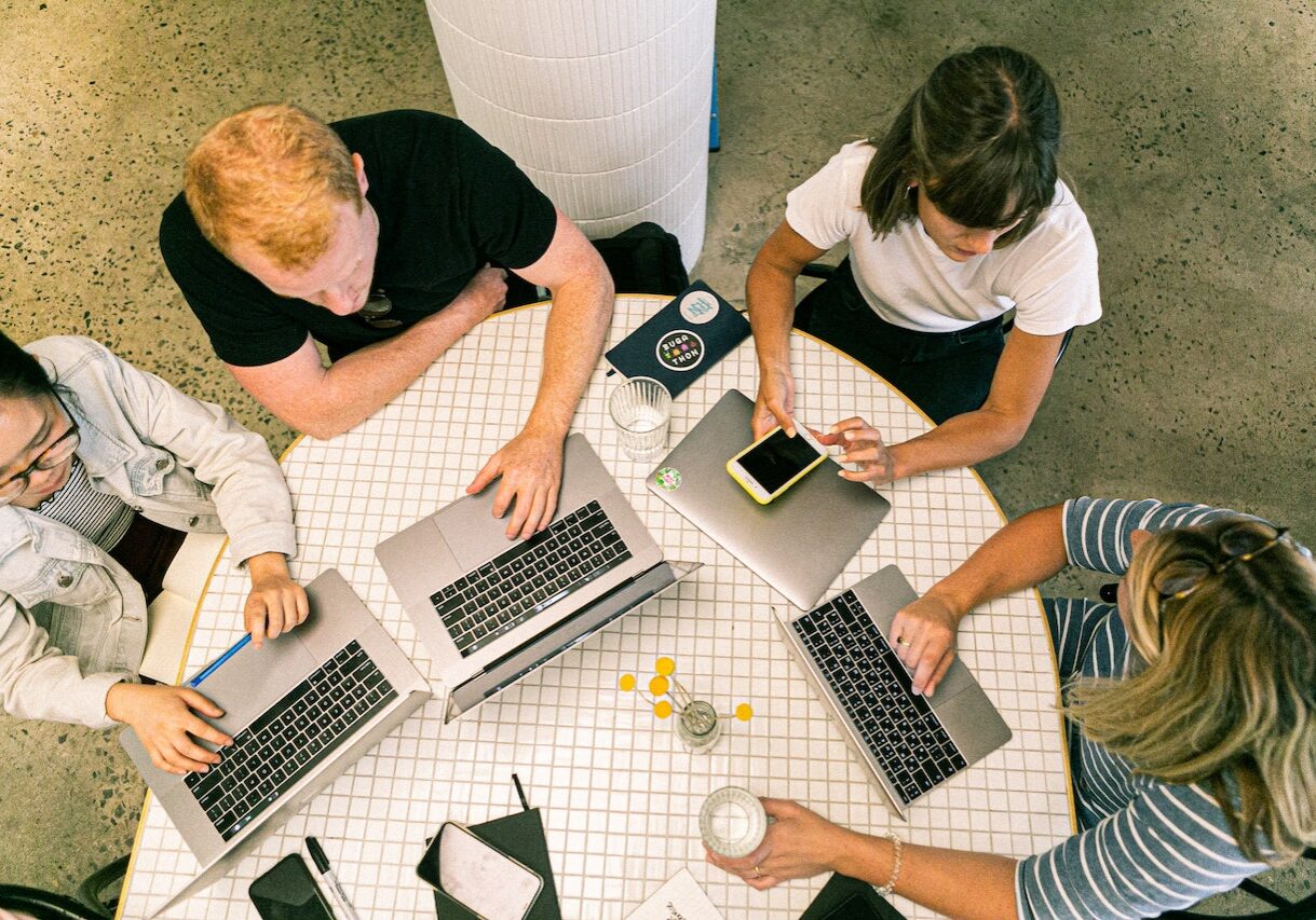 Four People Using Laptop Computers and Smartphone